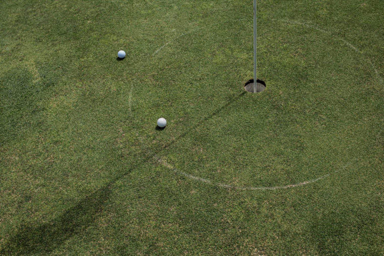 Top view of golf hole and balls