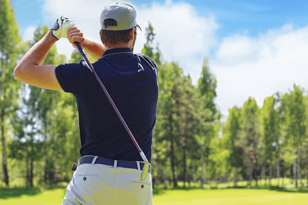 A golfer hits the fairway towards the club