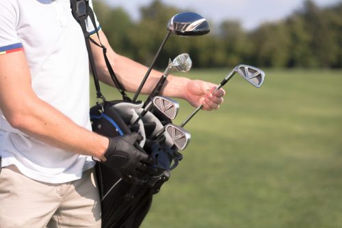 Man removing a golf club from his golf bag