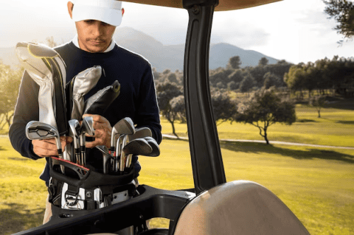 Front View of Man Putting Clubs in Golf Cart