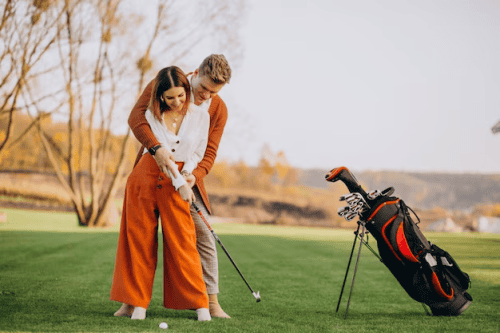 A guy and a girl playing golf