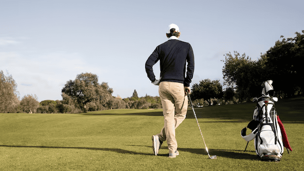 A man is standing on a golf club
