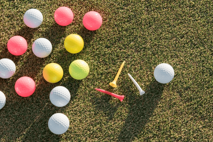 Various colors of golf balls scattered on the grass