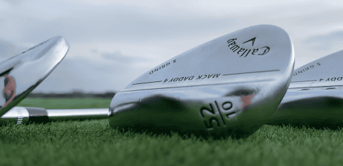 A close-up view of golf clubs resting on the grass