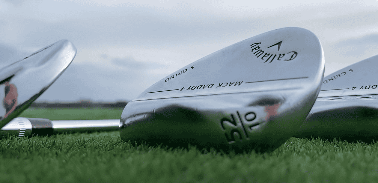 A close-up view of golf clubs resting on the grass
