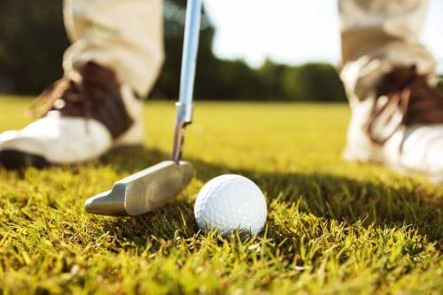 Close up of a man hits the ball with a golf club