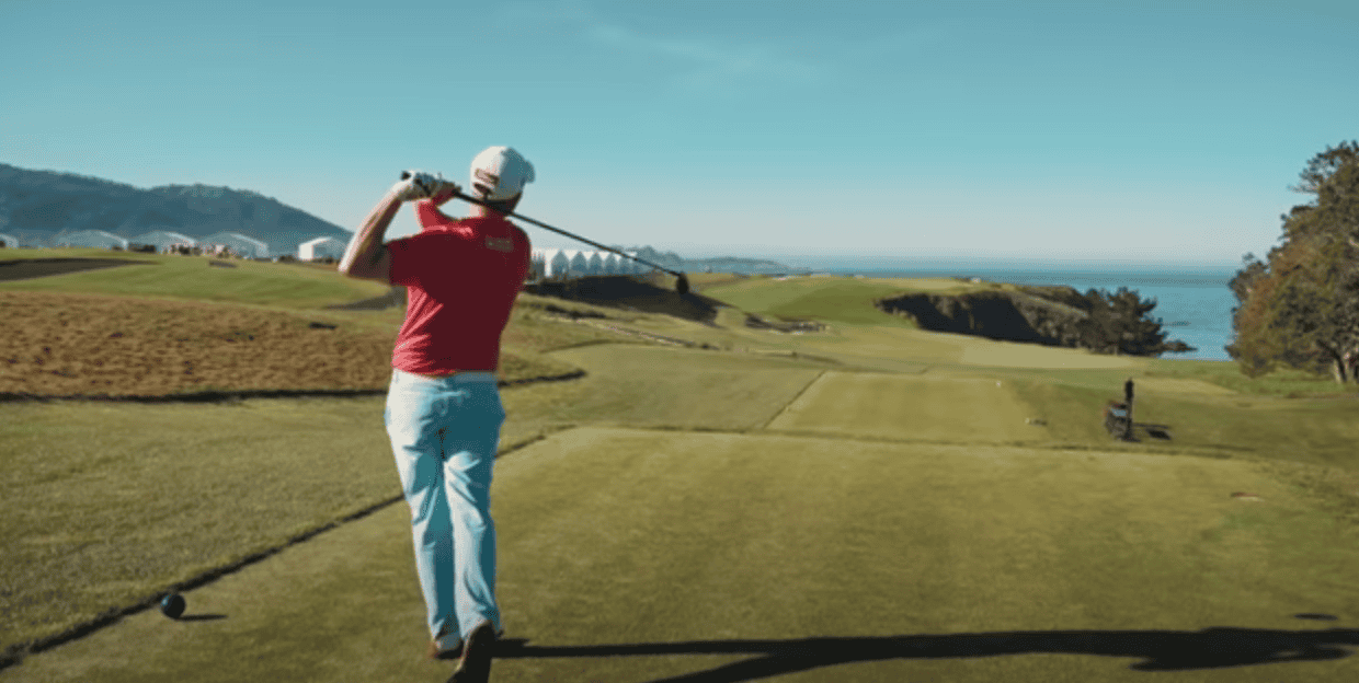 Man with a golf club over his shoulder after striking the ball on the golf course