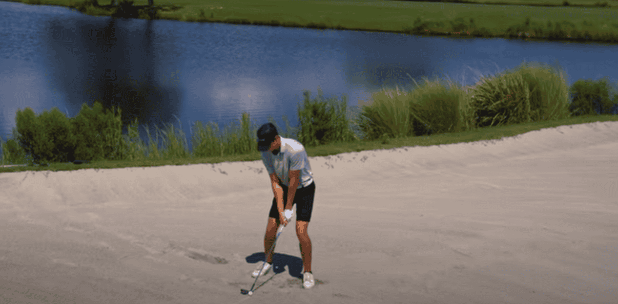 Man golfing on a lakeside golf course