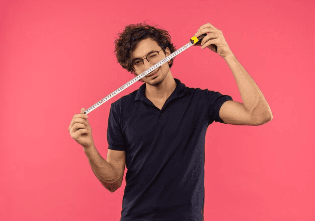 Man with glasses holding a measuring tape