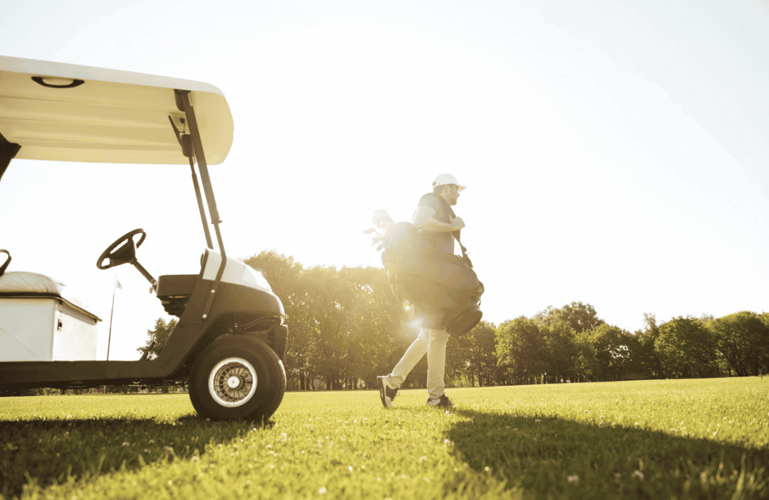 A man walks by the golf cart.
