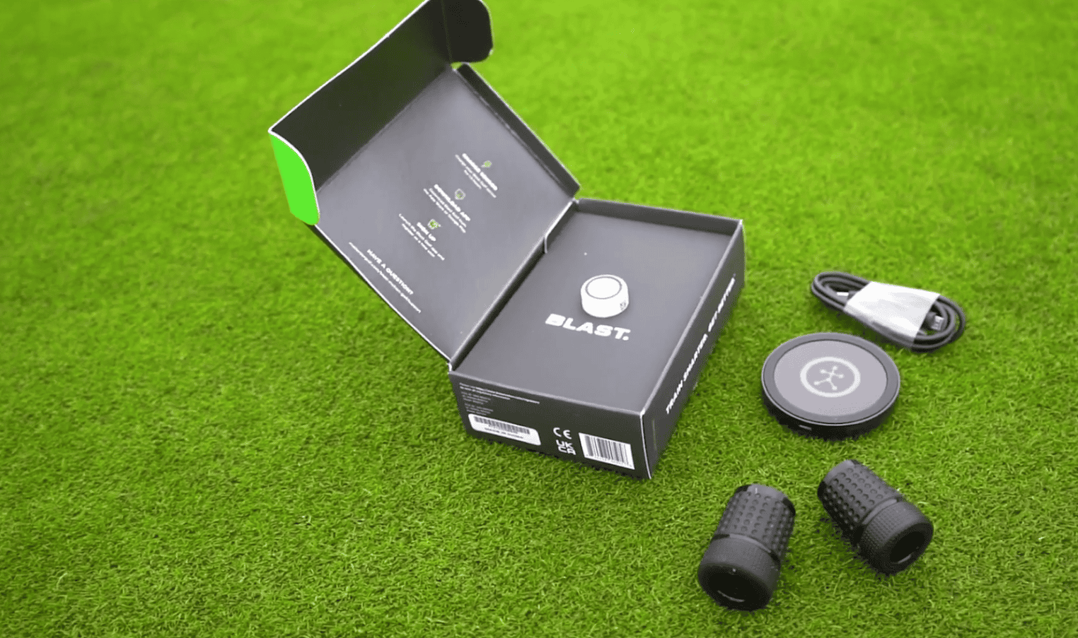 an opened box of blast golf with accessories for it on golf field