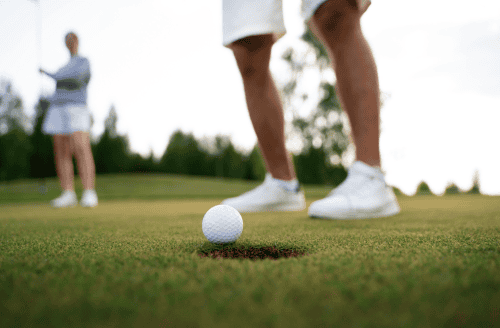 Two people playing golf.